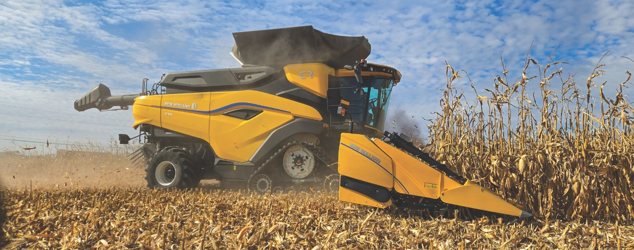 New Holland combine with corn header in the field