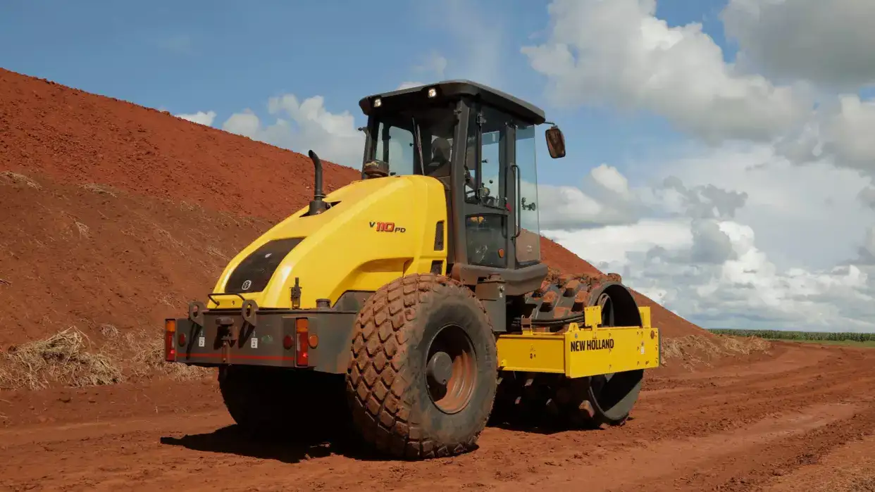 foto ao ar livre, do rolo compactador New Holland Construction em operação, com destaque para a traseira. 