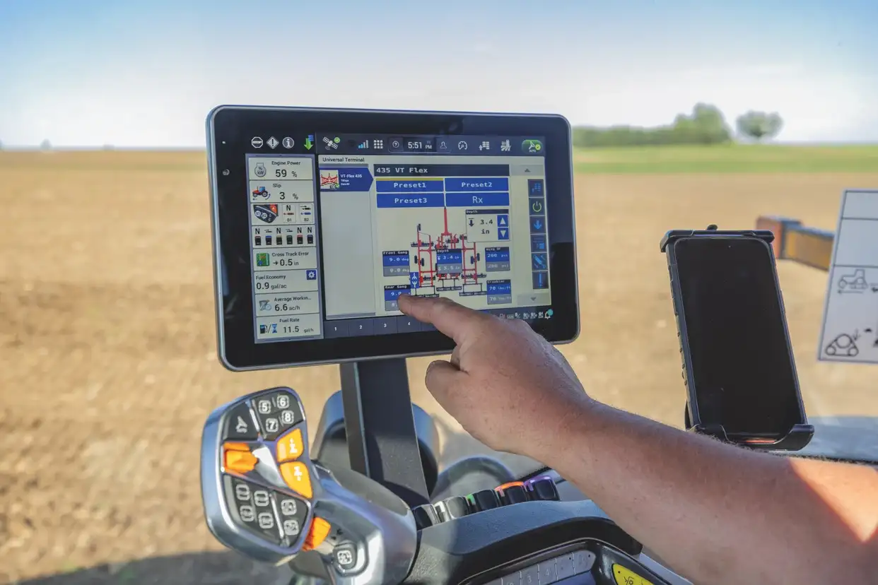 Farm equipment operator customizing display settings on a Case IH Pro 1200 screen inside a cab.