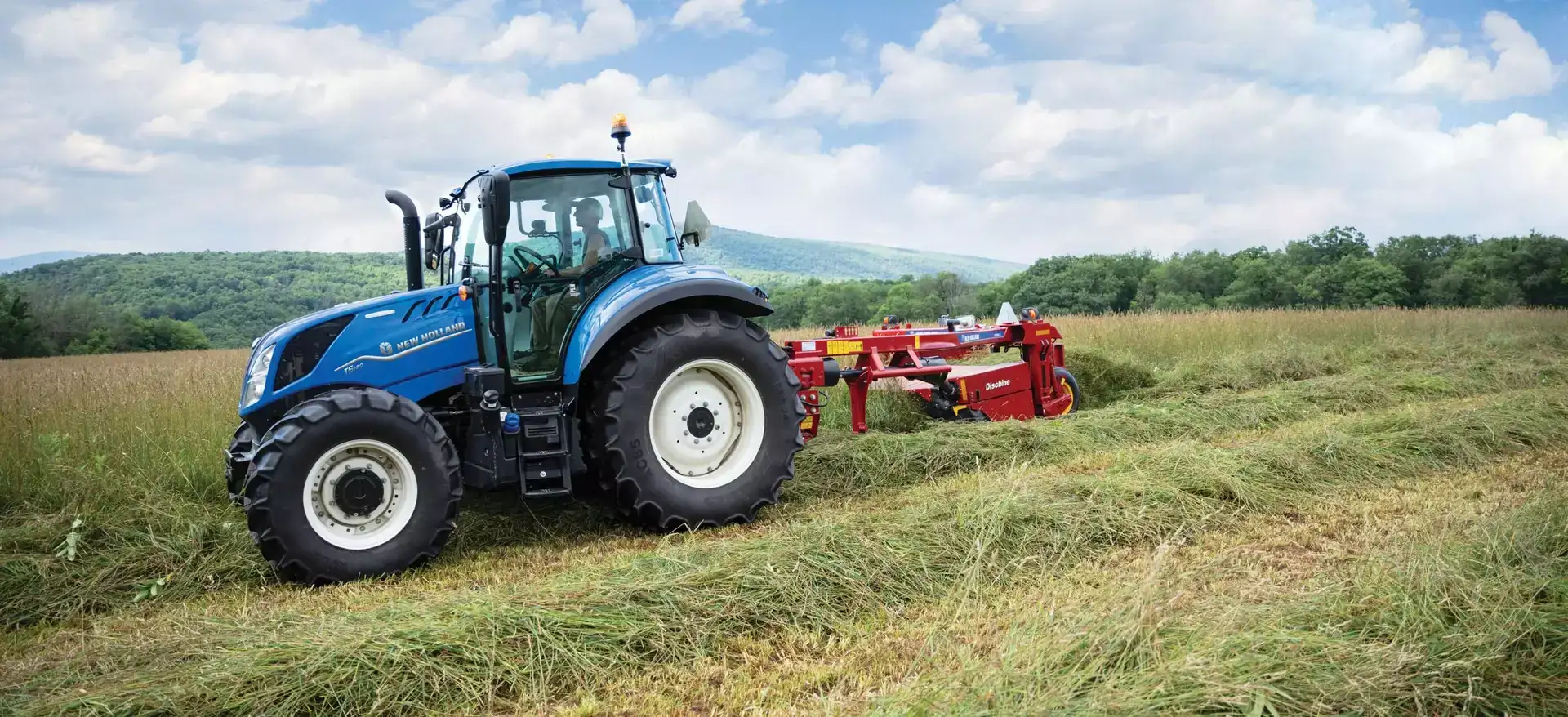 T5 Series tractor pulls a disc mower-conditioner