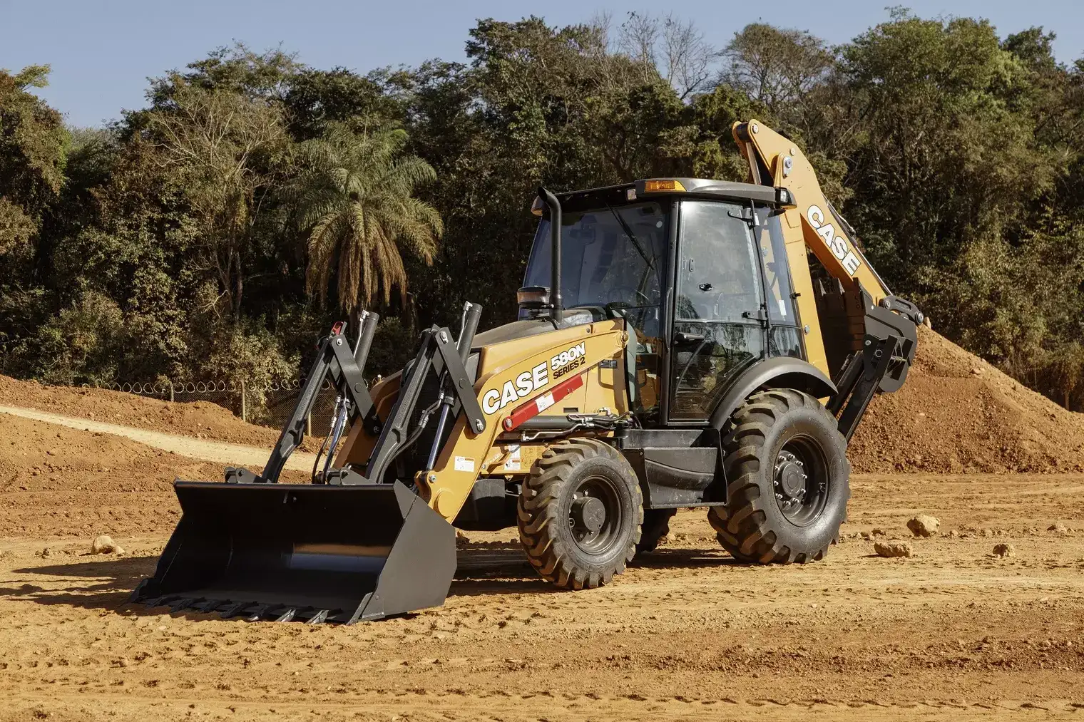 foto ao ar livre, com destaque para a lateral esquerda da retroescavadeira da Case Construction.