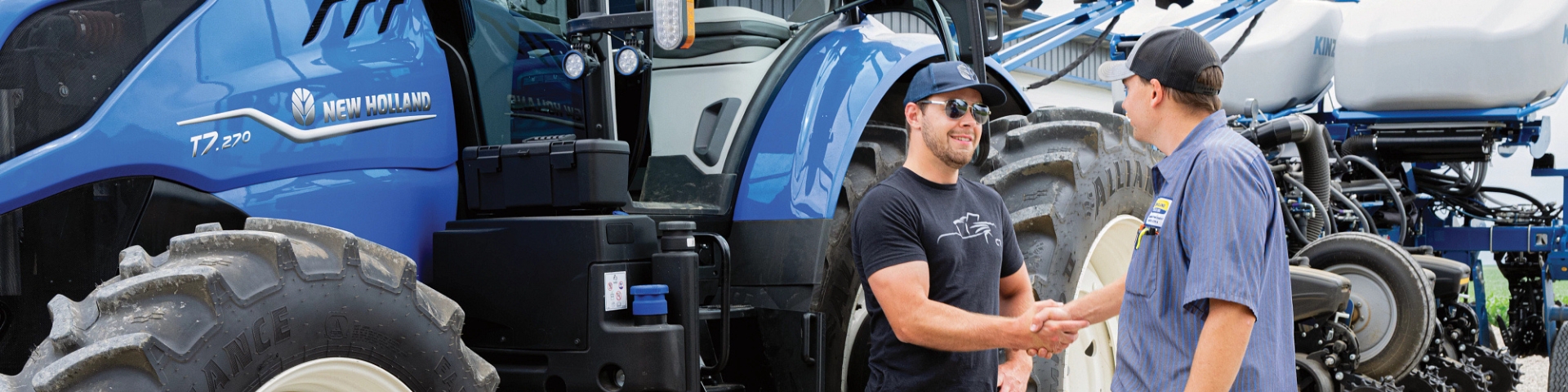 Customer shakes hands with a New Holland dealer in front of a T7 tractor.