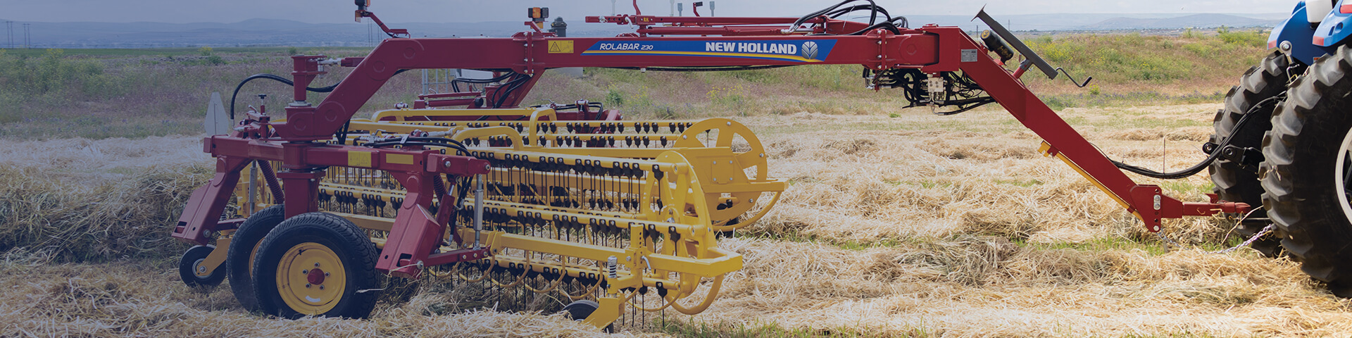 New Holland Rollbar rake 230 working in field with tractor