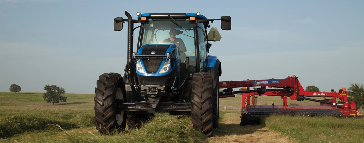 T6 tractor pulling an implement in the field