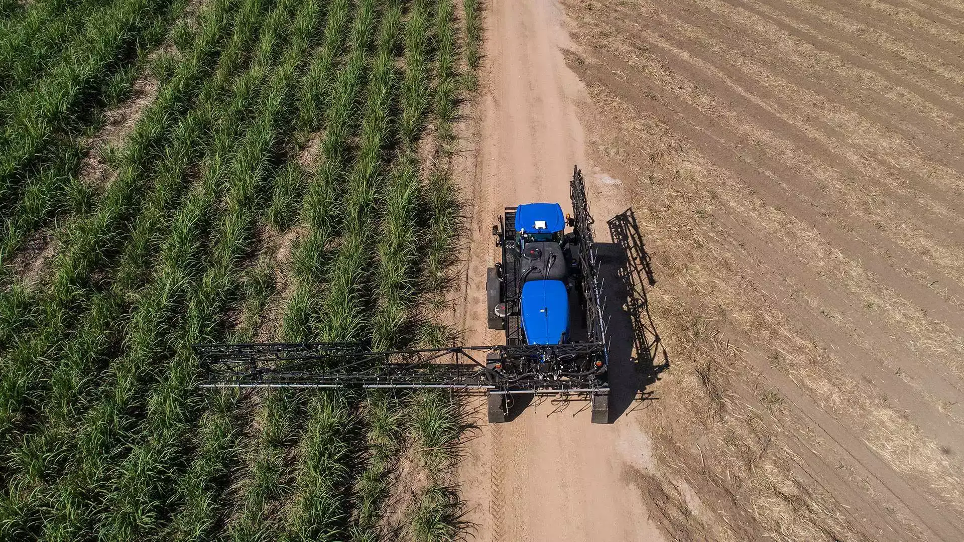 pulverizadores new holland modelo defensor 2500 cana de açúcar em campo com um braço aberto