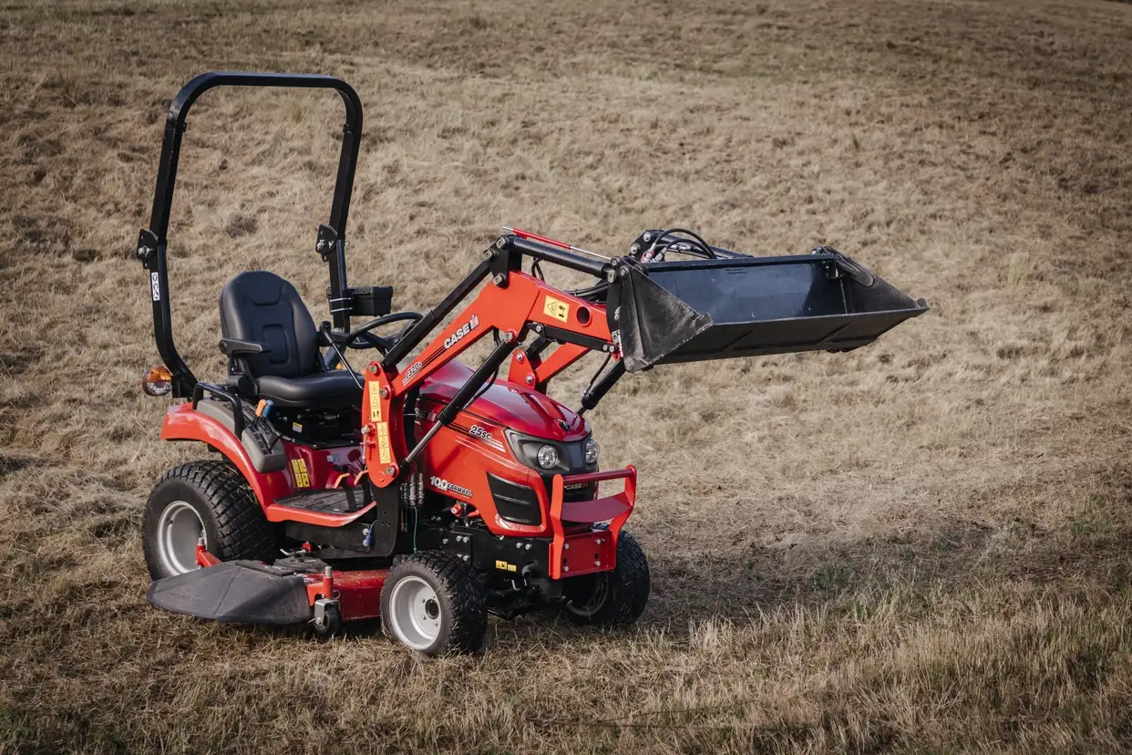 Farmall Subcompact tractor sitting in field with front loader