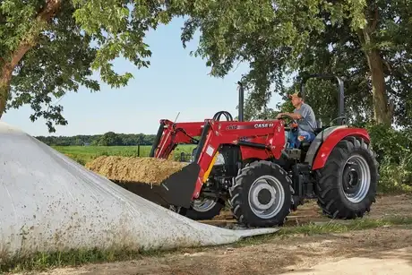 Farmall 75a with L610 Loader in front of wrapped hay