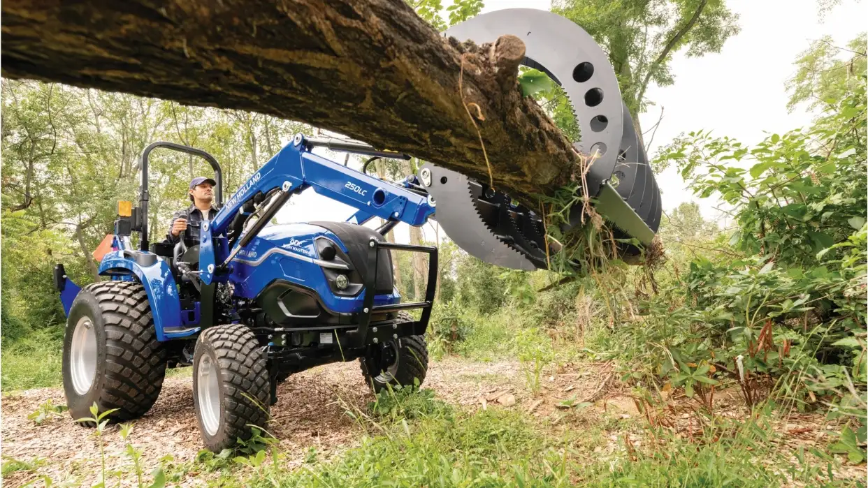 Tractor lifting wooden log.