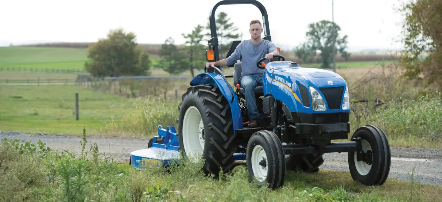 Man operates WORKMASTER tractor with a mowing implement