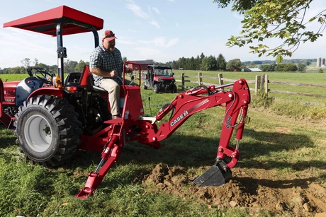 Man operating backhoe on Farmall 25A