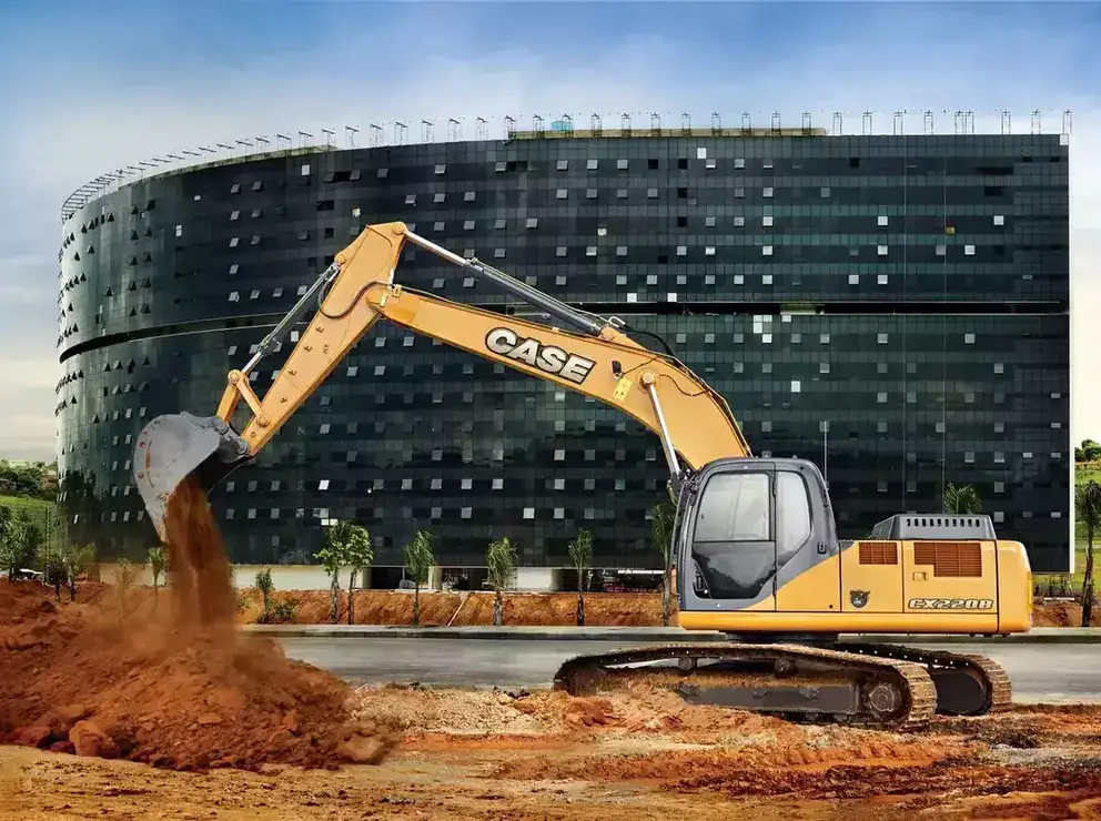 foto ao ar livre da escavadeira hidráulica da Case Construction transportando terra em frente a uma grande construção elaborada por Oscar Niemeyer.