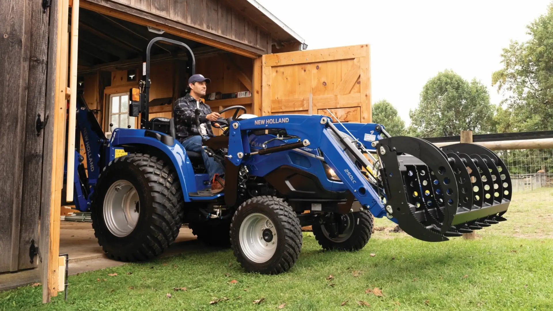 Man driving tractor out of shed.