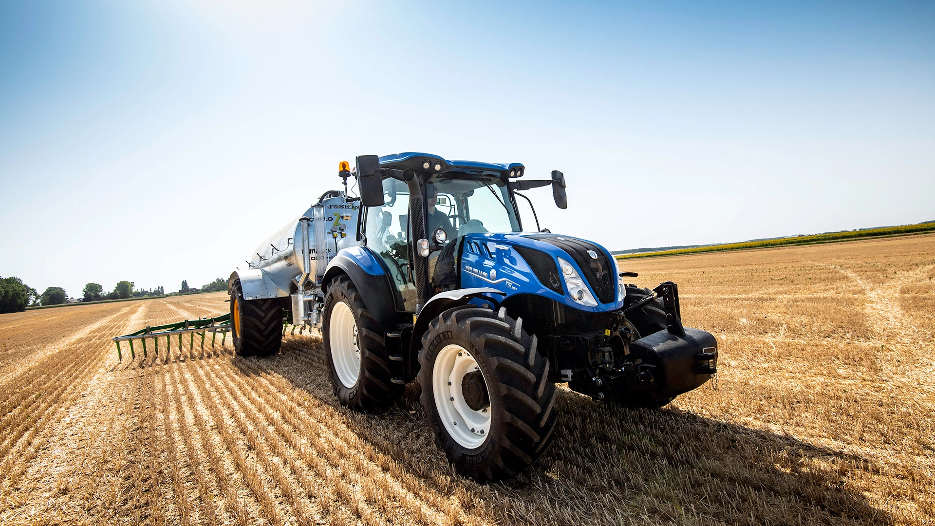 Farming tractor New Holland T5 Dynamic Command & Auto Command in action on agricultural land