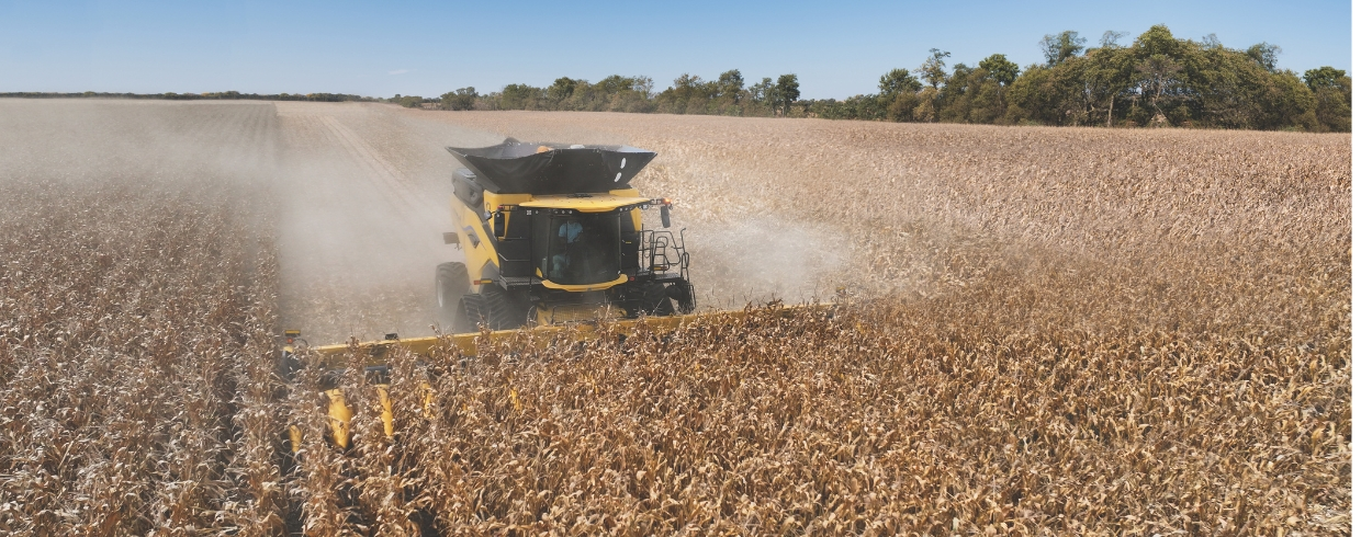 New Holland combine with corn header in the field