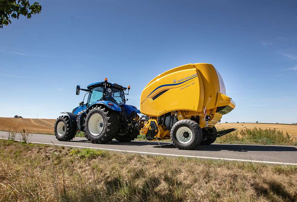 New Holland tractor with baler on road