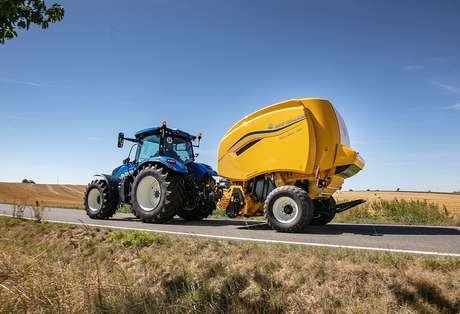 New Holland tractor with baler on road