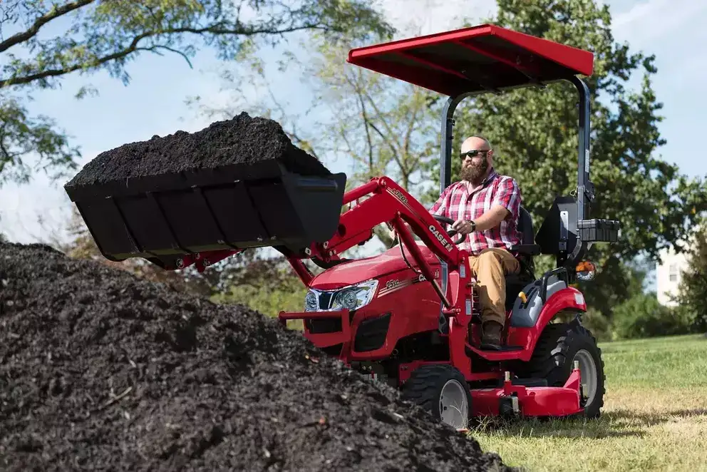 man on Farmall 25sc operating loader with bucket