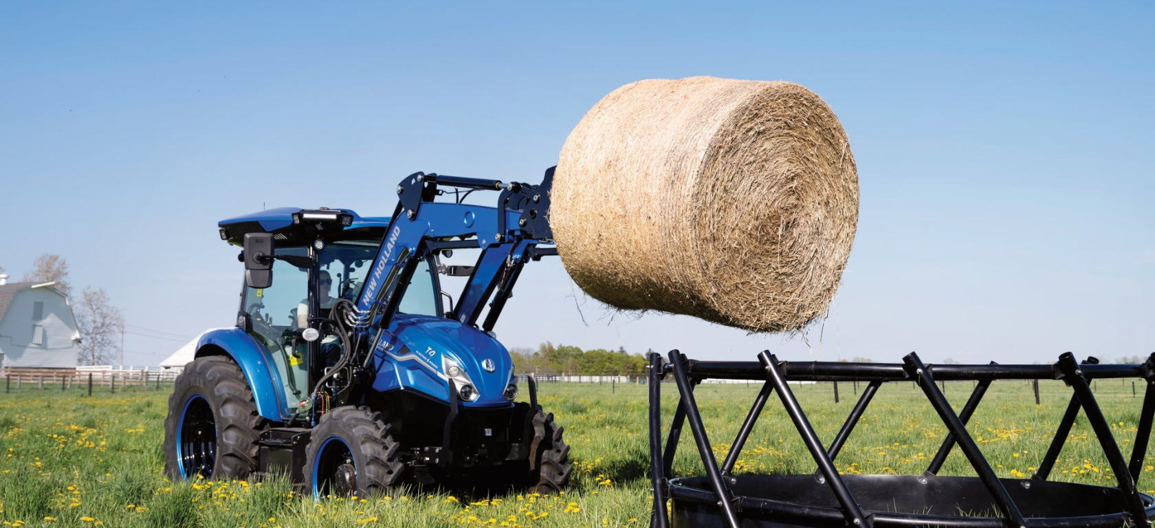 T4 Electric Tractor holding a bale