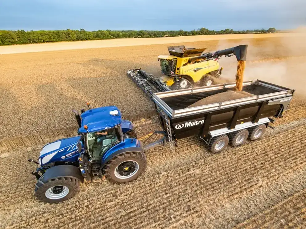 Working New Holland CR combine in field dispensing seeds