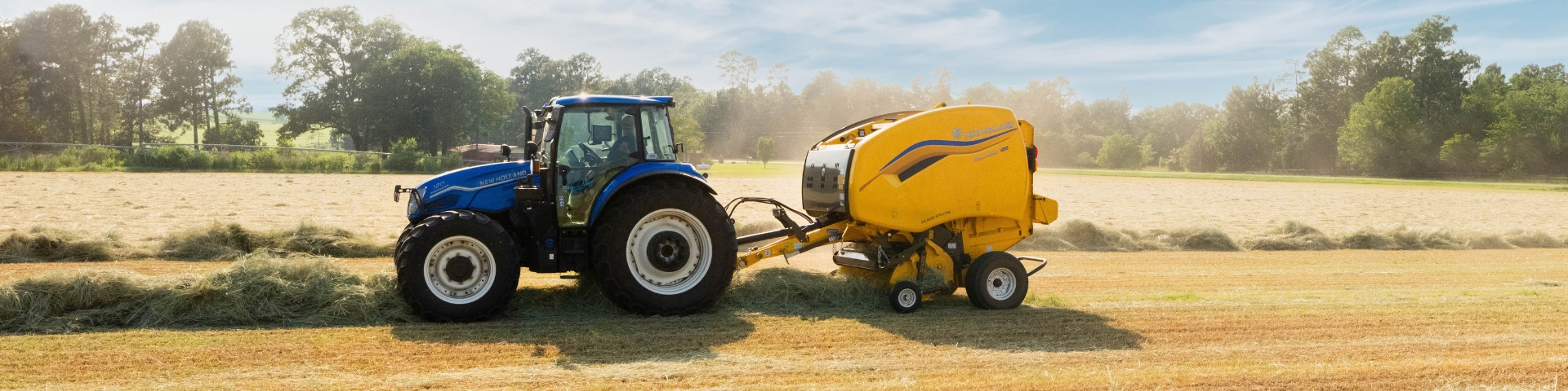 Tractor pulling baler in a field.