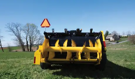 Beaters on the back of a yellow box spreader.