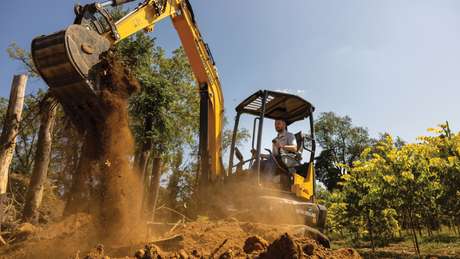 Mini Excavator digging up dirt.