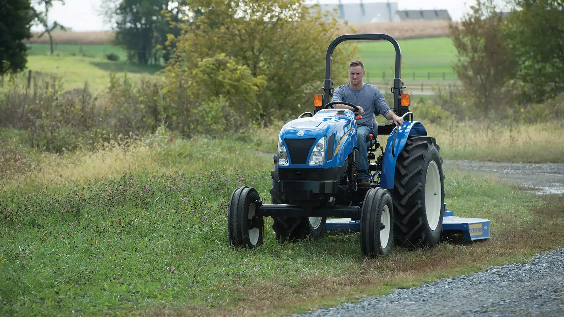Man operates WORKMASTER tractor with a mowing implement