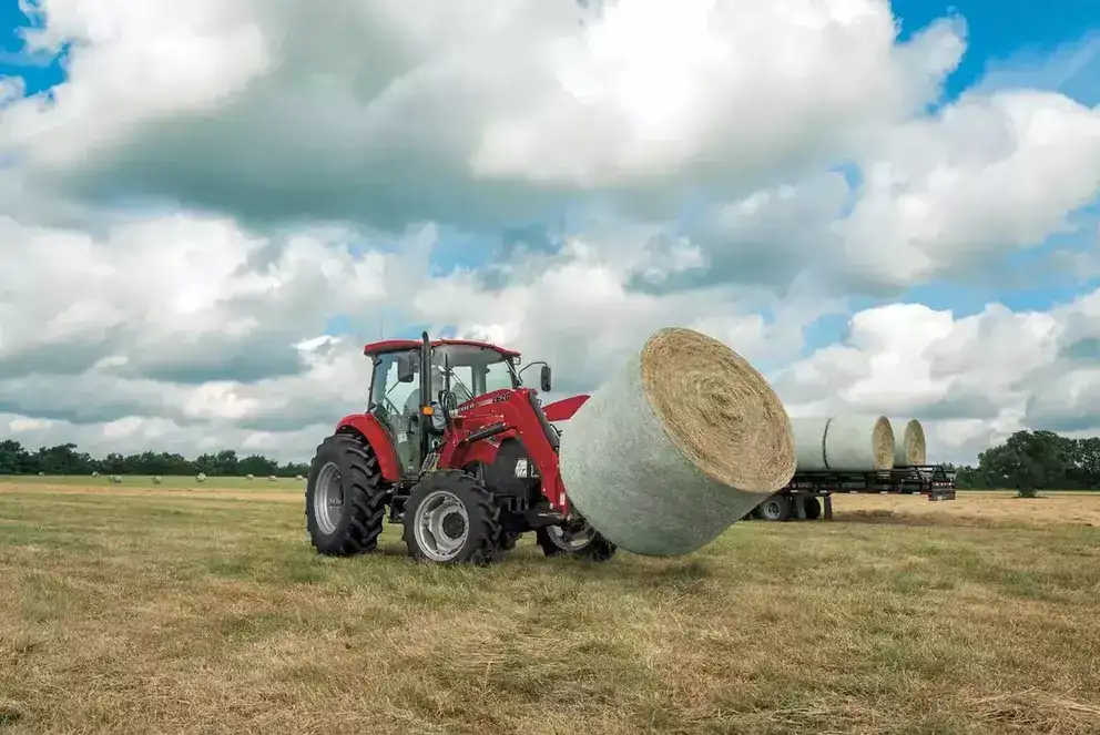Farmall Utility 75C tractor with L620 Loader with wrapped hay. 