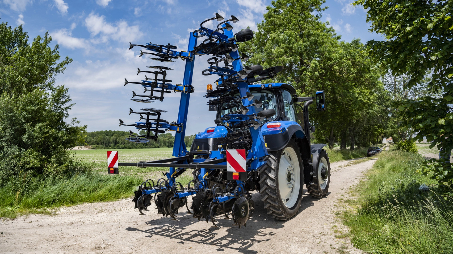 Tractor on a roadway transporting SRC & SRC SmartSteer Interrow Cultivators to the next agricultural site