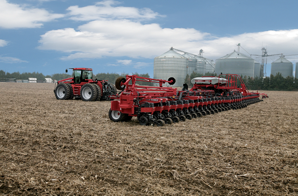 Case IH Early Riser Planter 1260 in front of storage silos