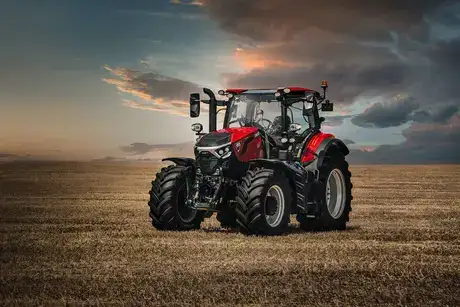 Red Case IH Puma Series 185 tractor sitting in field, with sunset backdrop