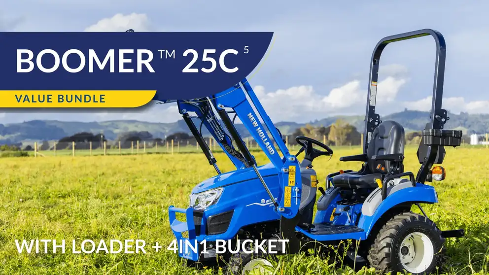 New Holland Boomer 25C tractor sitting in field with operator