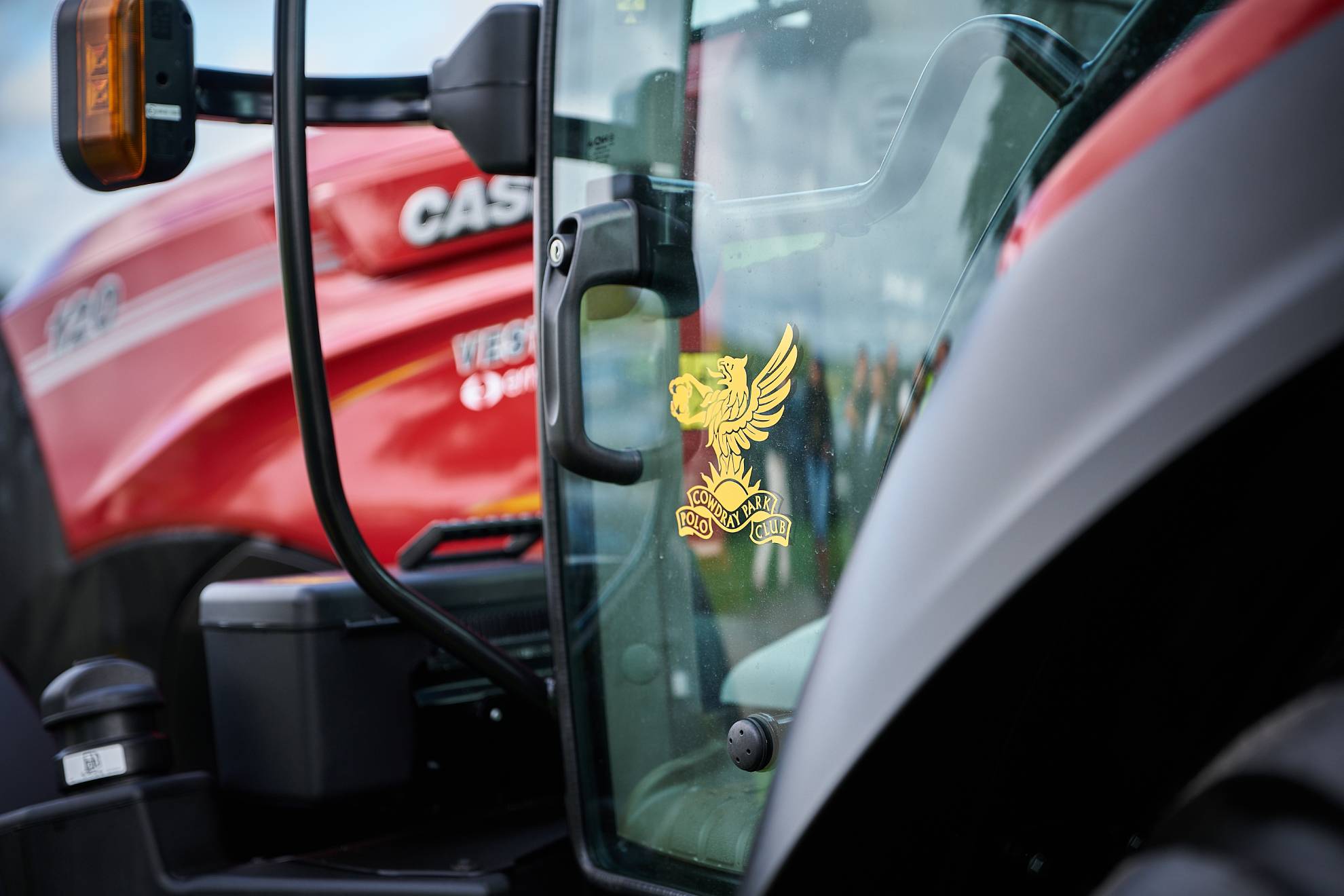 Close-up of a Case IH tractor cab featuring the Cowdray Park Polo Club crest.