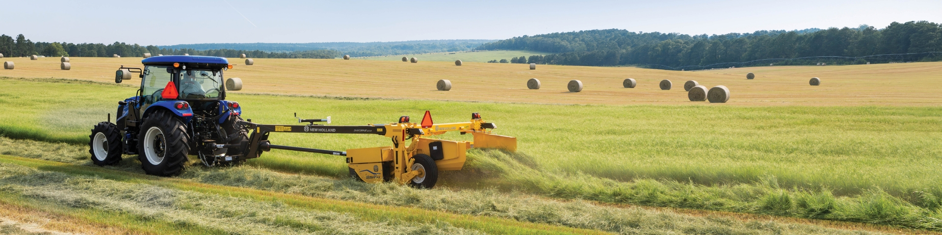 Tractor mowing hay in a field.