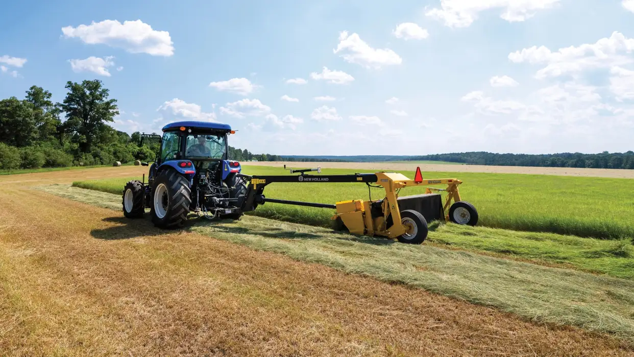 New Holland tractor pulling disc mower.