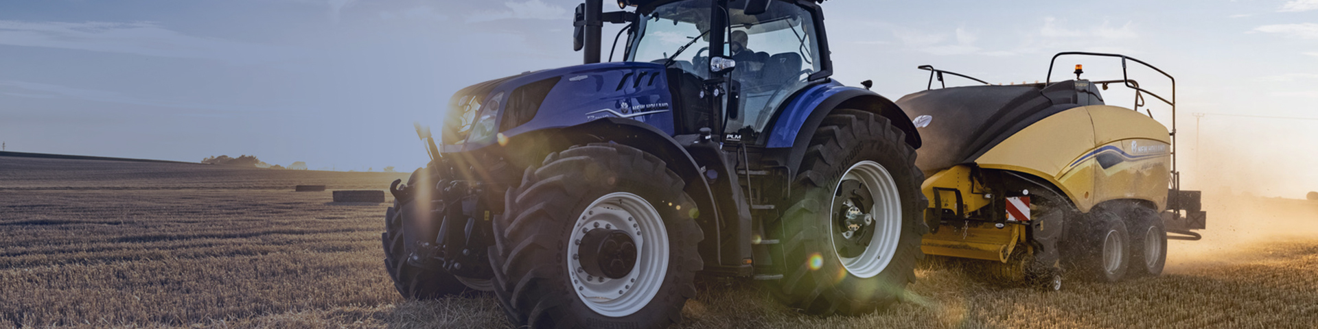 New Holland BigBaler Plus in field with a New Holland tractor