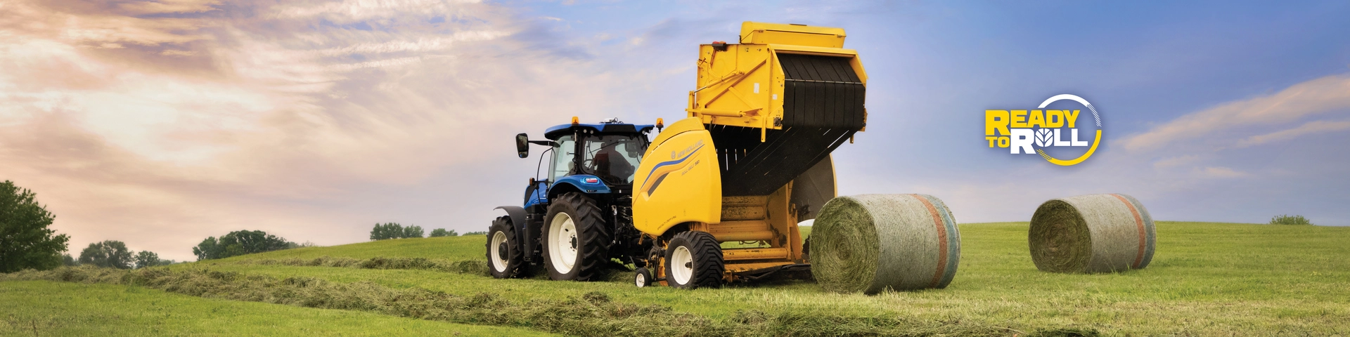 New Holland tractor with baler is used to bale hay in a field.