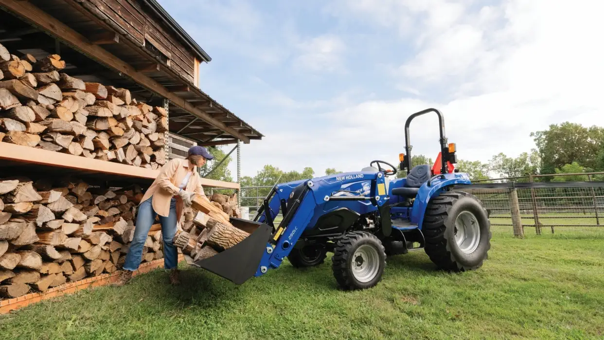 Person placing firewood into tractor bucket.