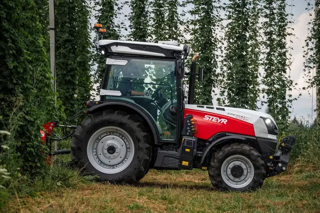 Seitenansicht eines STEYR Spezial 4120F Obstbautraktors in einer Hopfenanlage