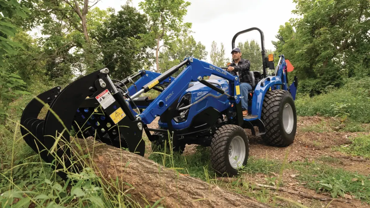 Tractor grabbing wooden log.