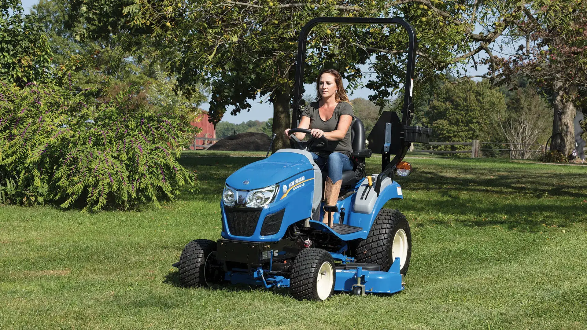 Woman operates WORKMASTER 25S tractor with a belly mower