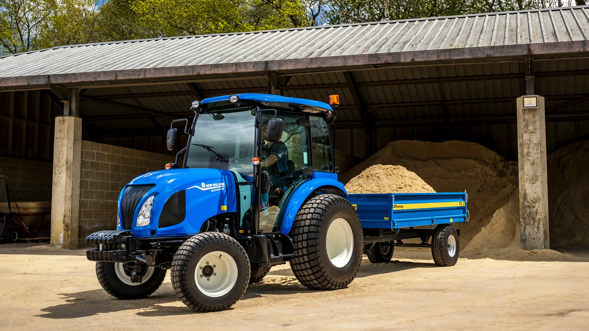 New Holland Boomer 50 tractor carrying sand across the site