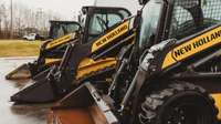Skid steer loaders line up.