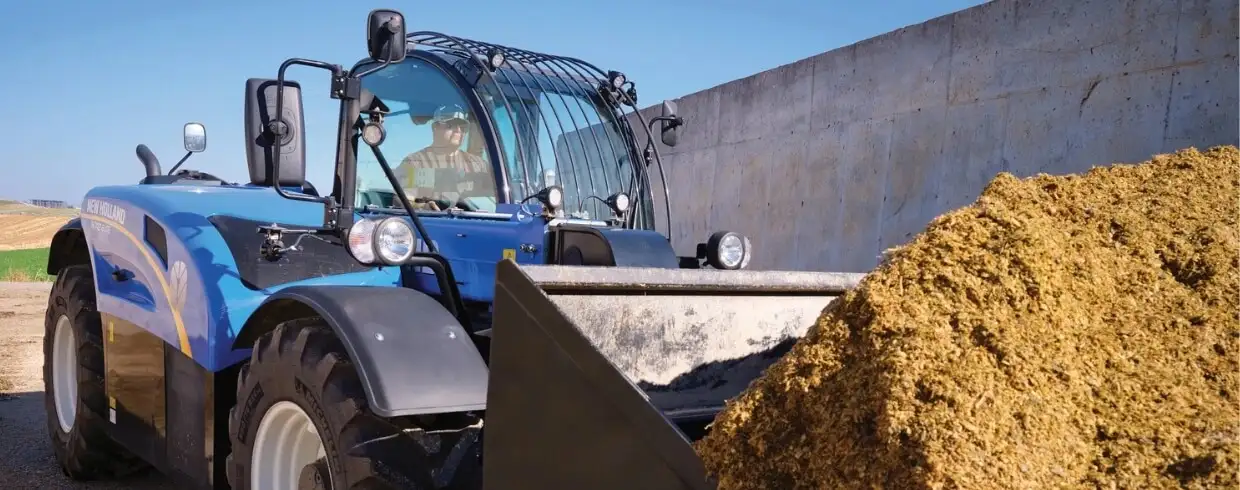TH Series telehandler lifts dirt in a bucket
