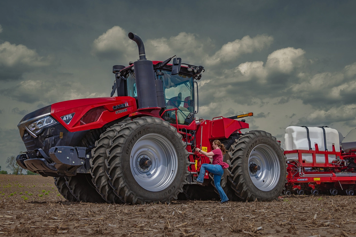 Steiger 475 in field with woman climbing into cab