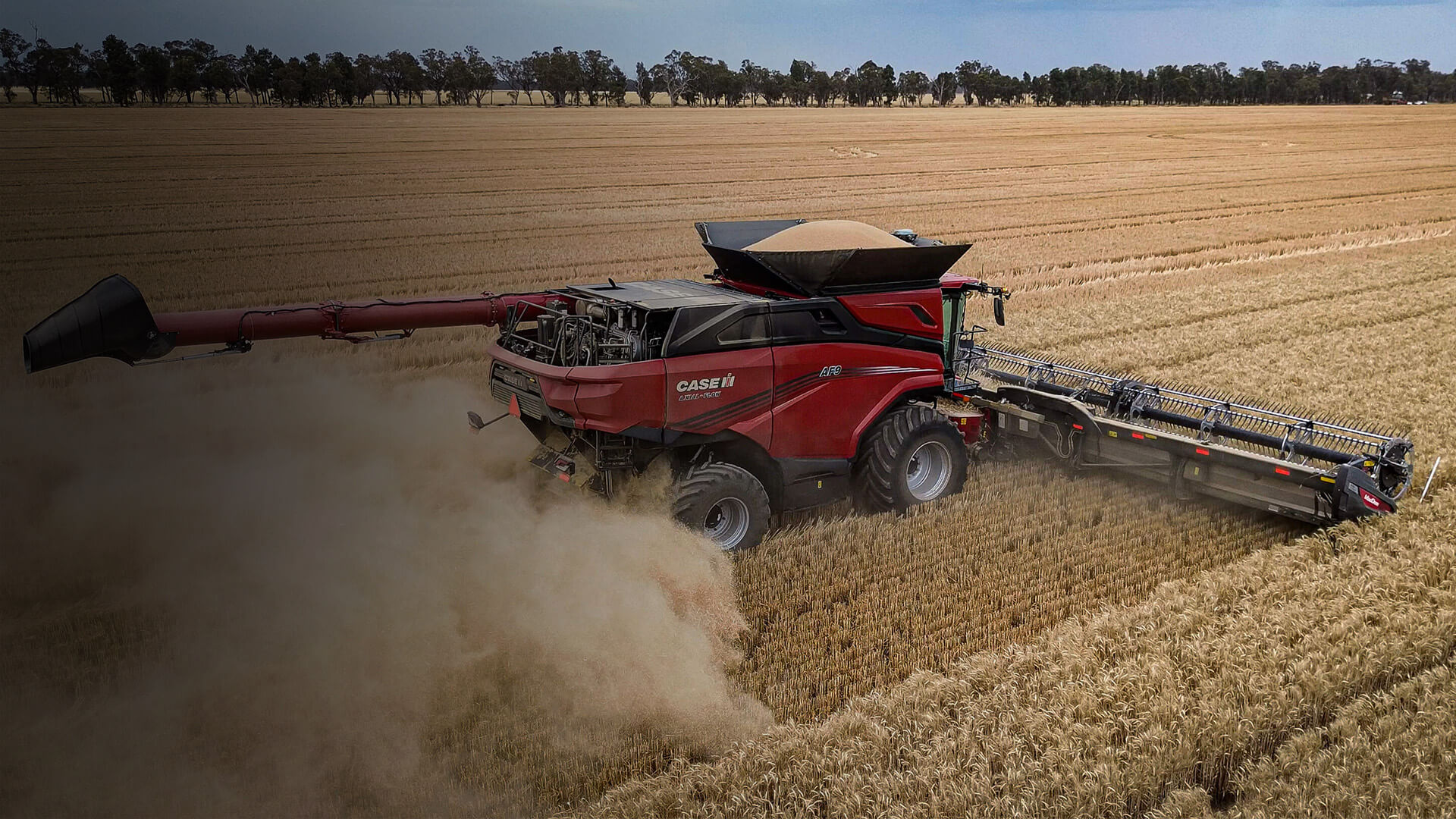 Red Case IH AF9 combine working in field with dark gradient overlay