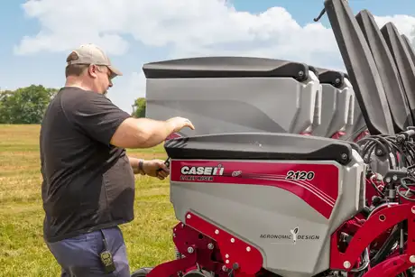 Operator examining hopper of Early Riser 2120 planter