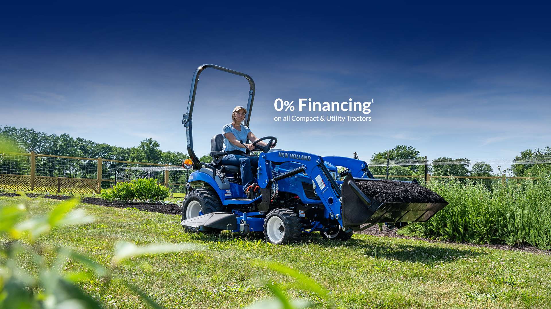 Blue tractor lifting dirt in a field.